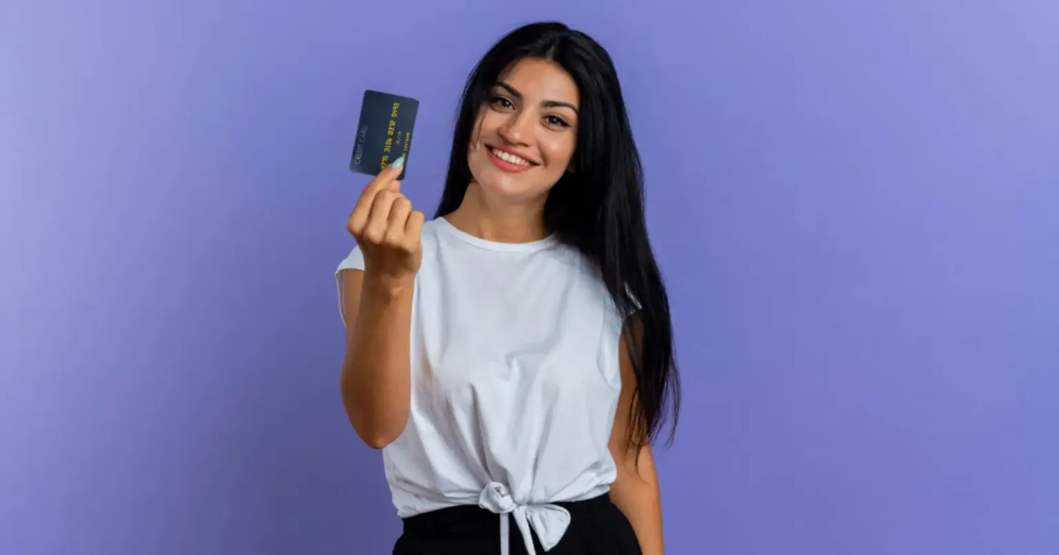 Woman holding a credit card representing smart credit card choices and financial lifestyle